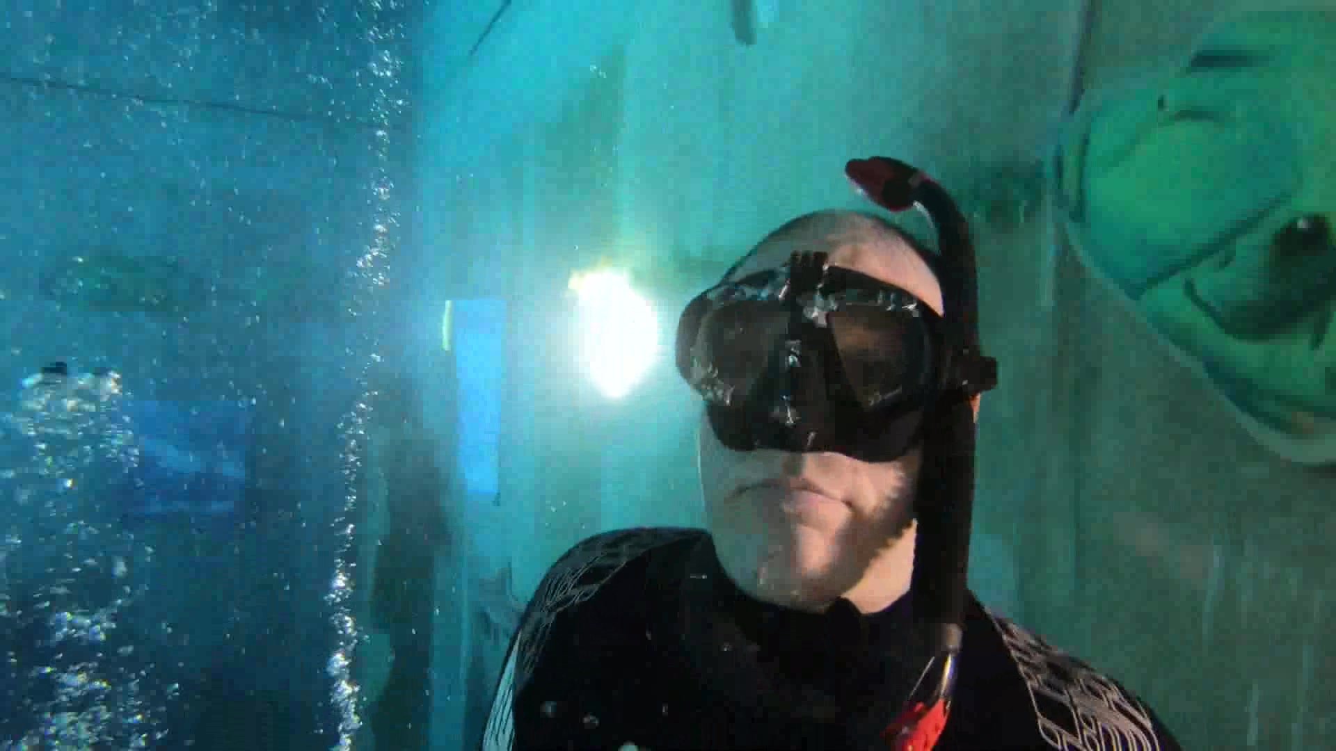 Freediving underwater in water tank and wetsuits