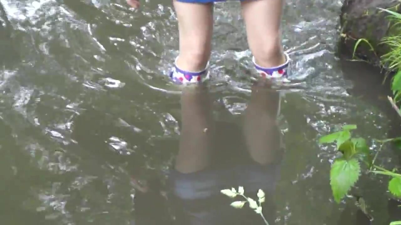 Girl in rubber boots in water