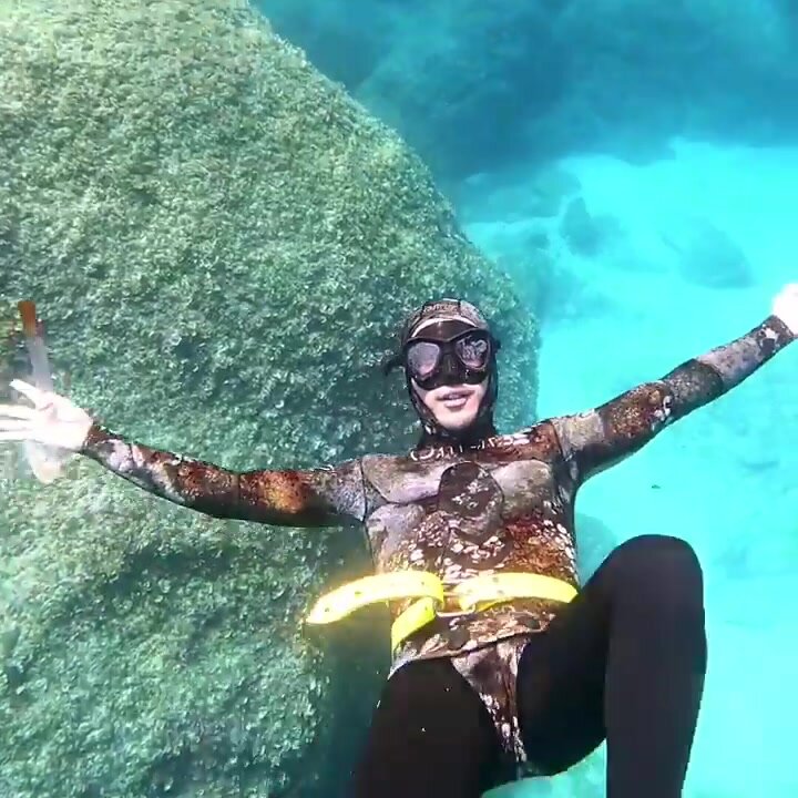 Happy freediver underwater in wetsuit