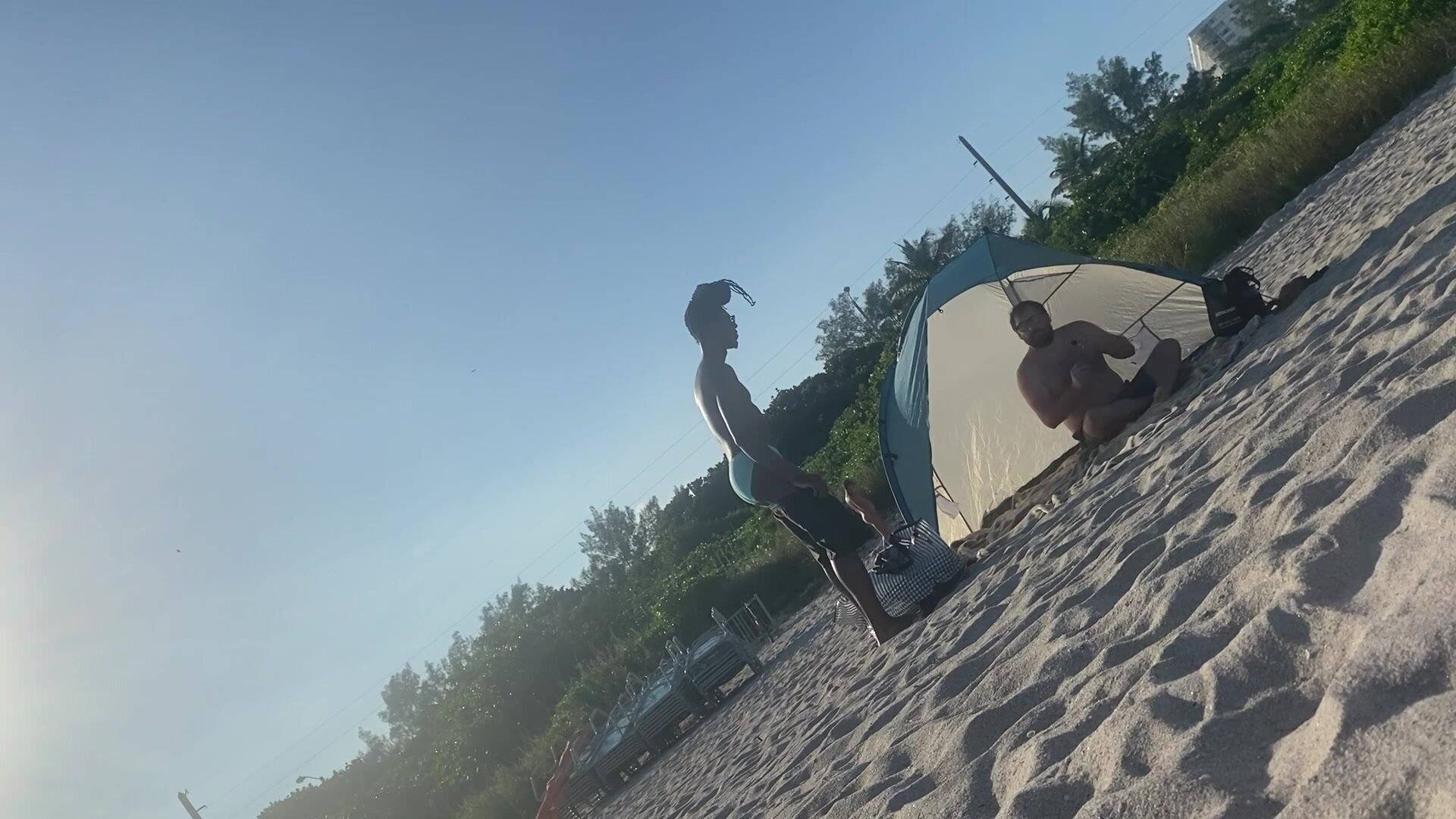 Guy stripping down at the beach.
