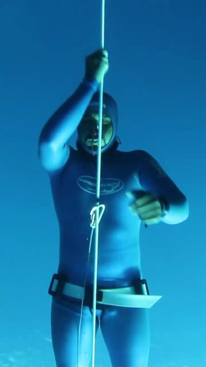 Beefy barefaced arab underwater in blue wetsuit