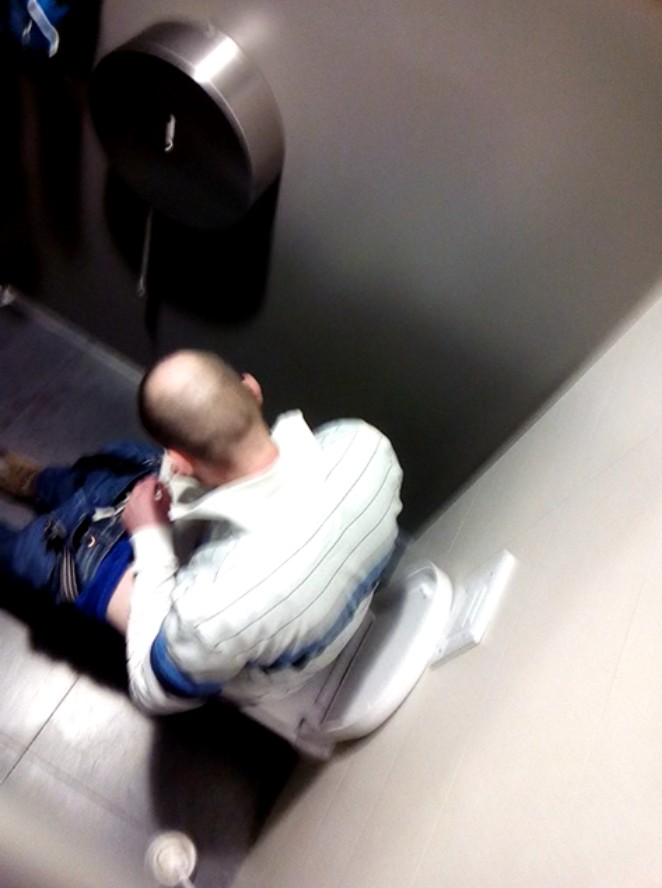 Guy sitting at the toilet