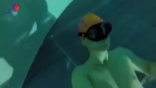 Freediving underwater with orange swimcap