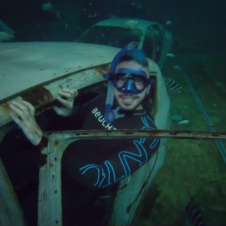 Freediver underwater in sunken car
