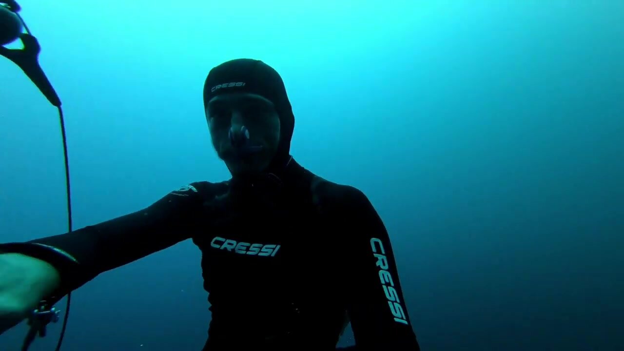 Barefaced freediver underwater in tight wetsuit - video 4