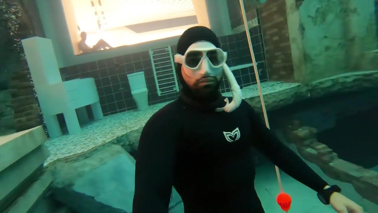 Arab hottie breatholding underwater in tight wetsuit