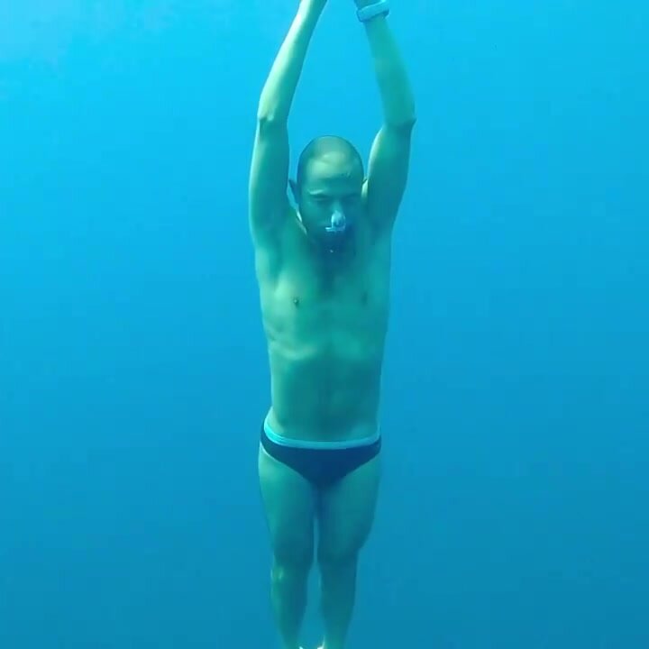 Barefaced underwater with noseclip and speedo