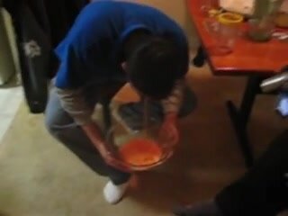 Drunk guy pukes into a bowl
