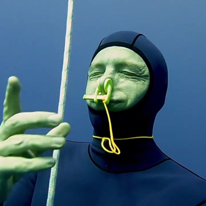 Barefaced underwater in wetsuit with noseclip