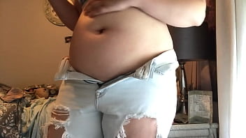 Girl holds her belly under t-shirt