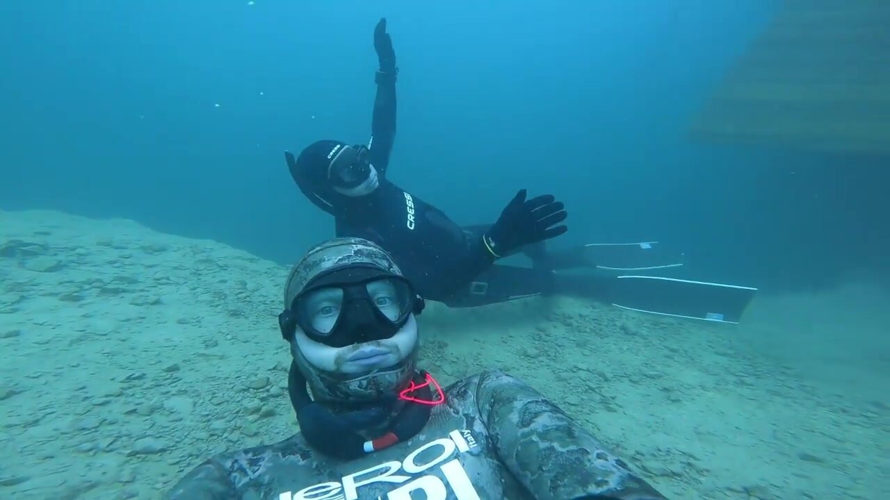 Freediving buddies underwater in wetsuits