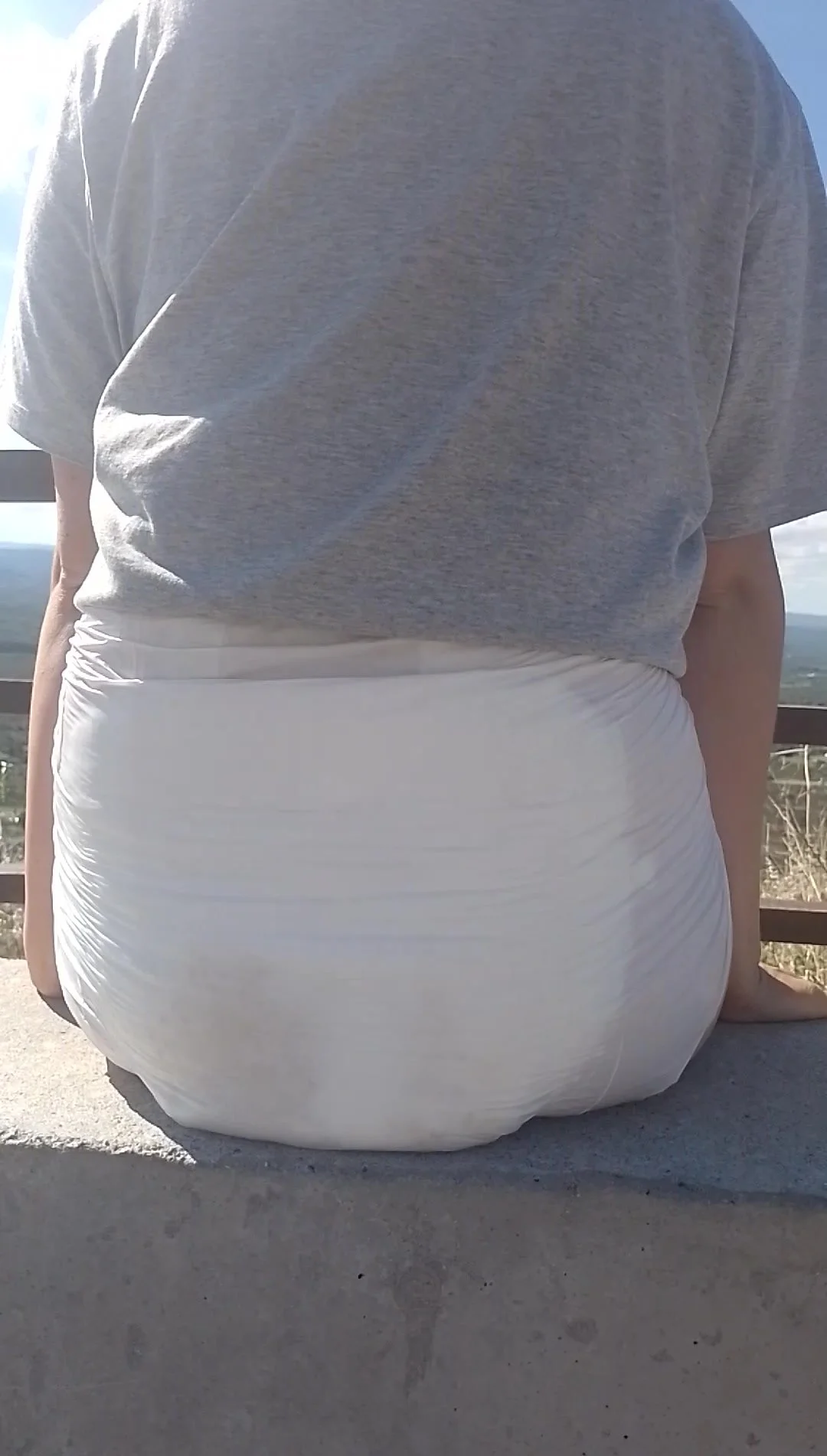 Girl walks in public with visibly wet diaper