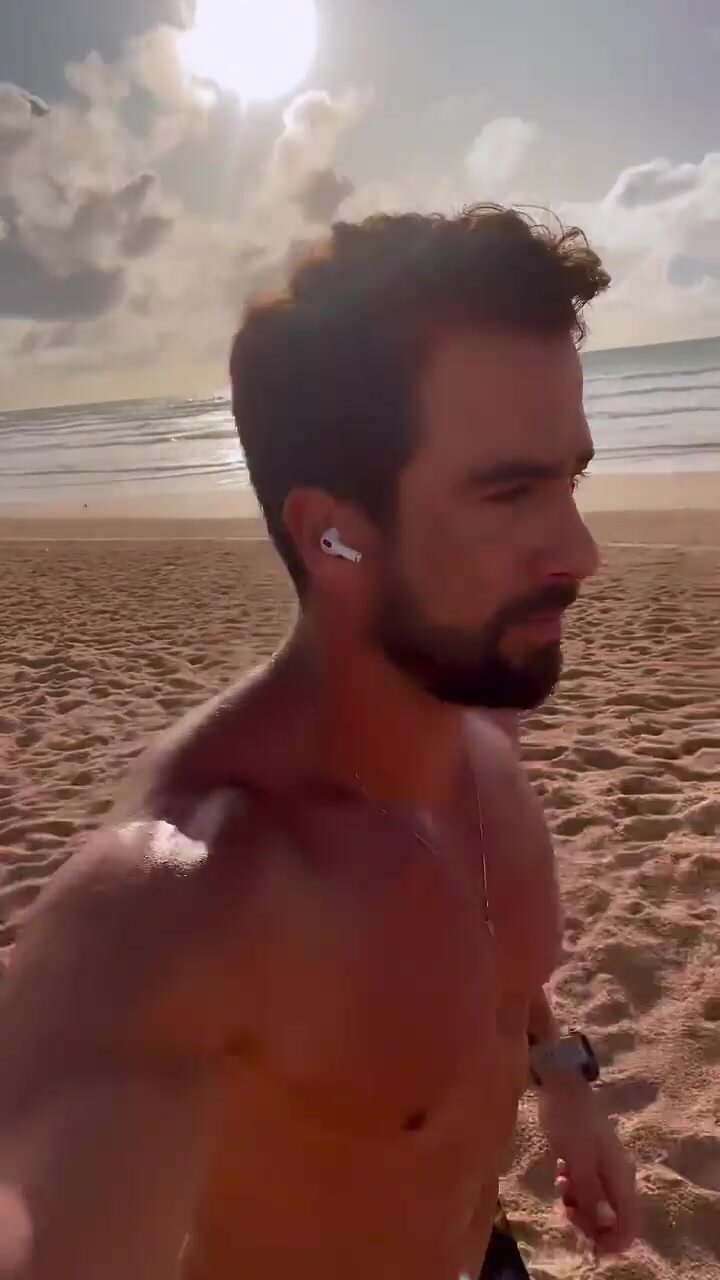 Handsome Man with Bouncy Pecs Jogs on the Beach