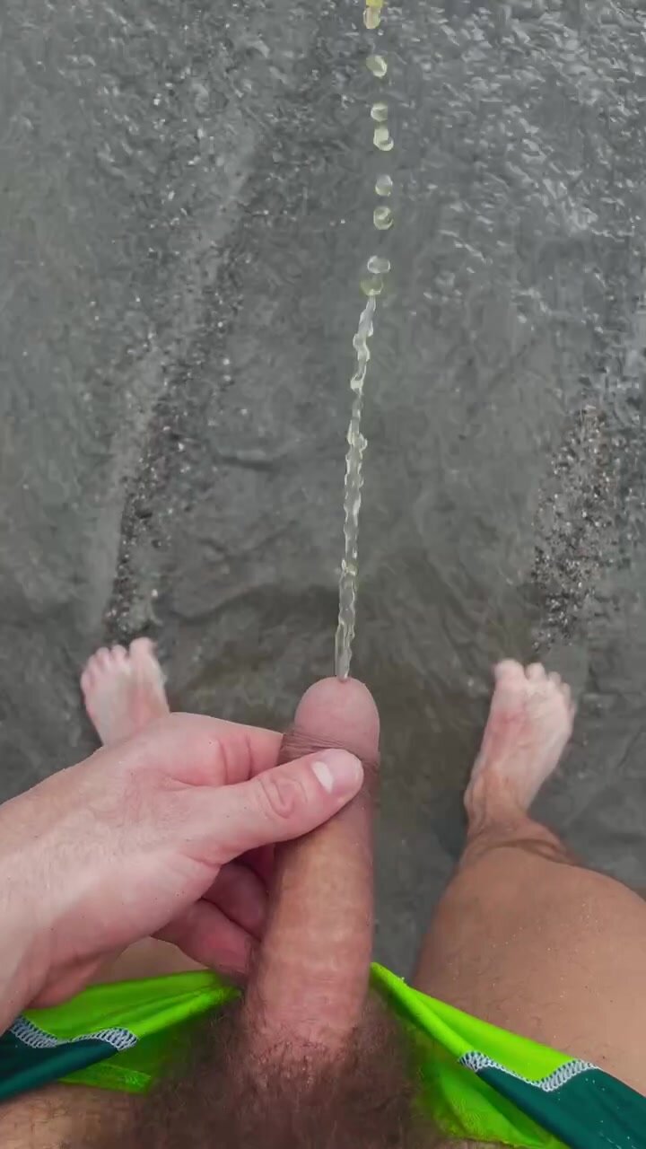 Boy pissing on beach in public