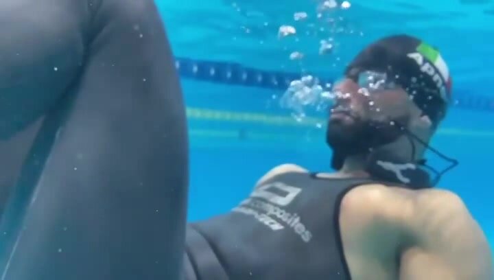 Italian freediver underwater in tight wetsuit