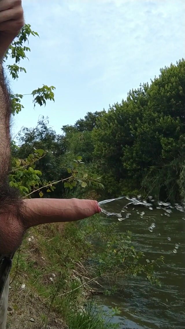 Uncut cock takes a piss in a stream