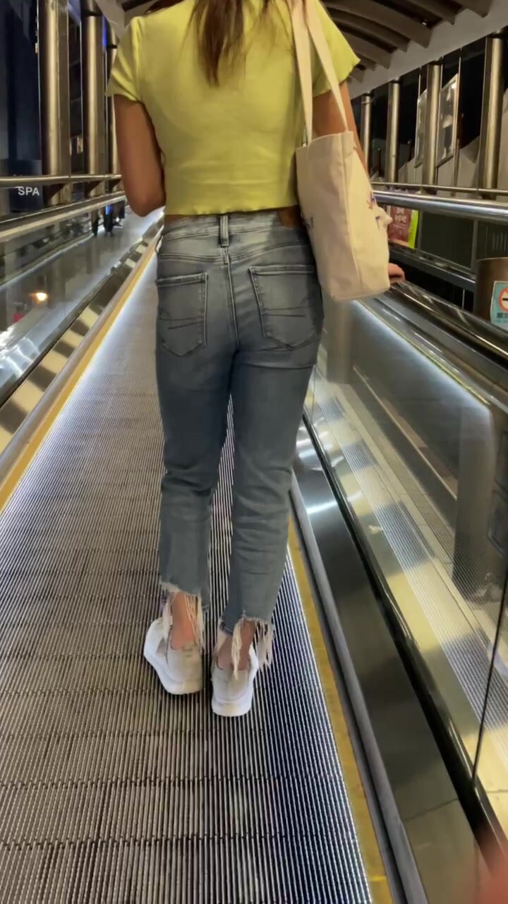 Girl wearing pad under jeans on Escalator