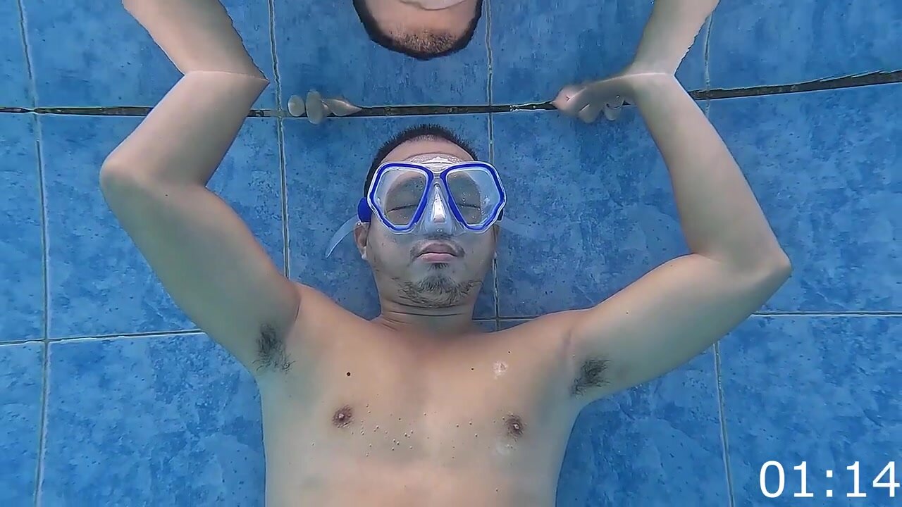 Asian guy breatholding and showing pits underwater