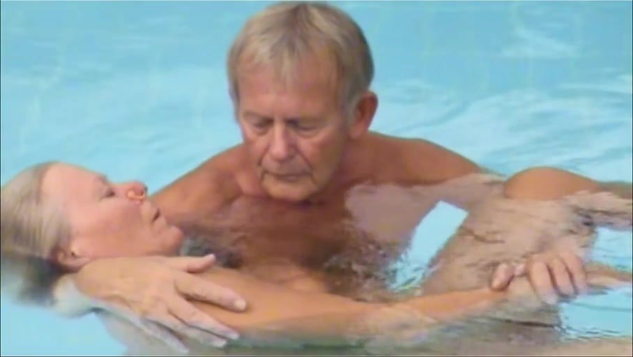 Old couple relaxing naked in pool