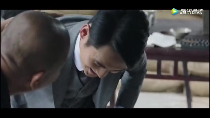 (humiliation scene) a man in a suit is  forced clean boots