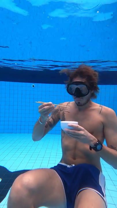 Breatholding guy reading book underwater