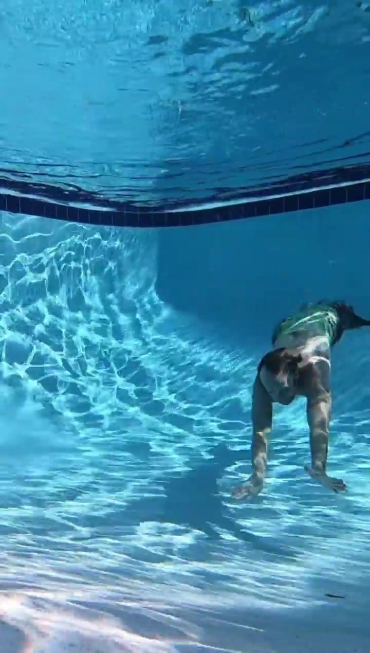 Underwater barefaced redhead merman in pool