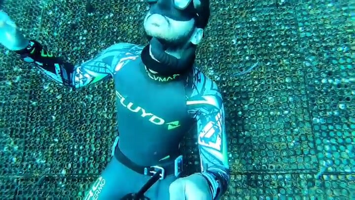 Arab freediver swimming throught air ring underwater