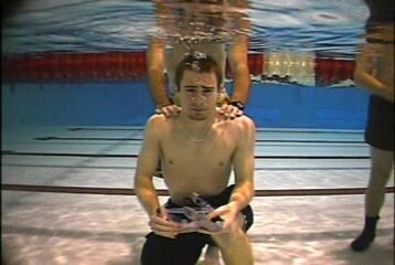 Underwater barefaced guy exhaling air in pool