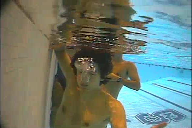Underwater barefaced guy letting air out in pool