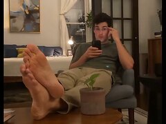 Sexy male actor putting his bare feet on the table