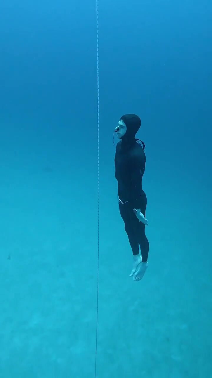 Diving deep underwater barefaced in tight wetsuit - video 2