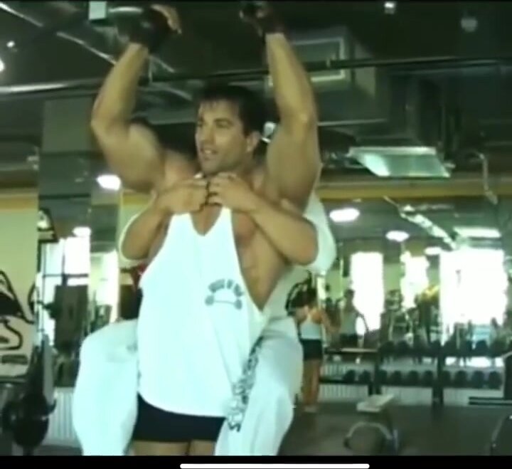 bodybuilder does workout with fat twink on his back