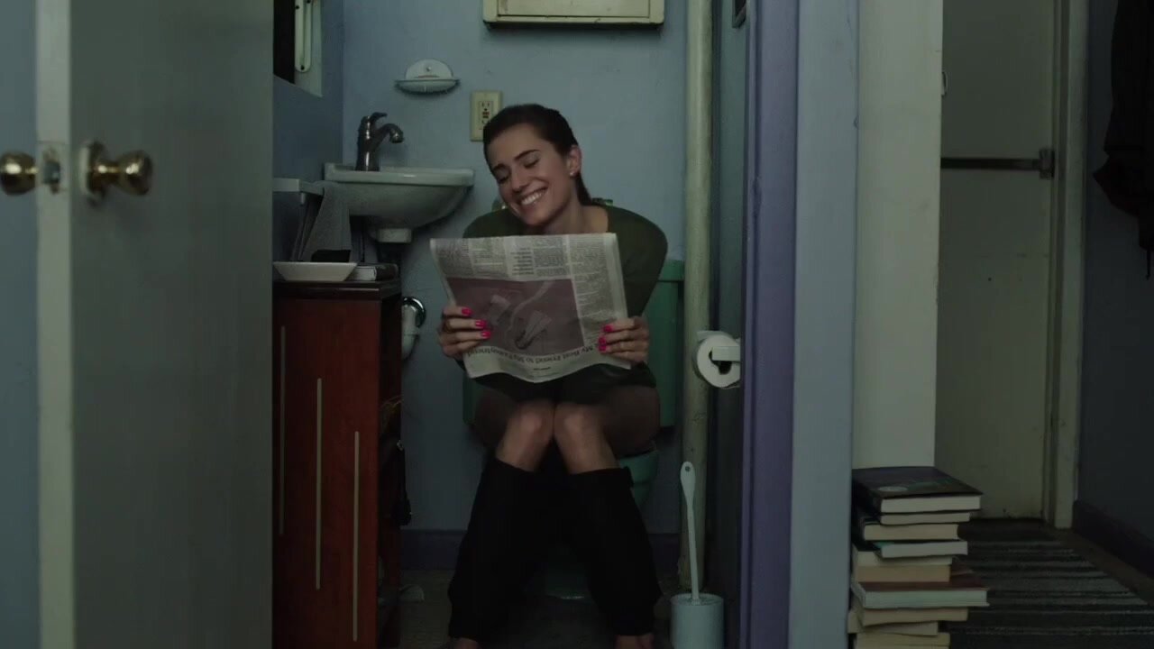 Woman on the toilet while reading newspaper