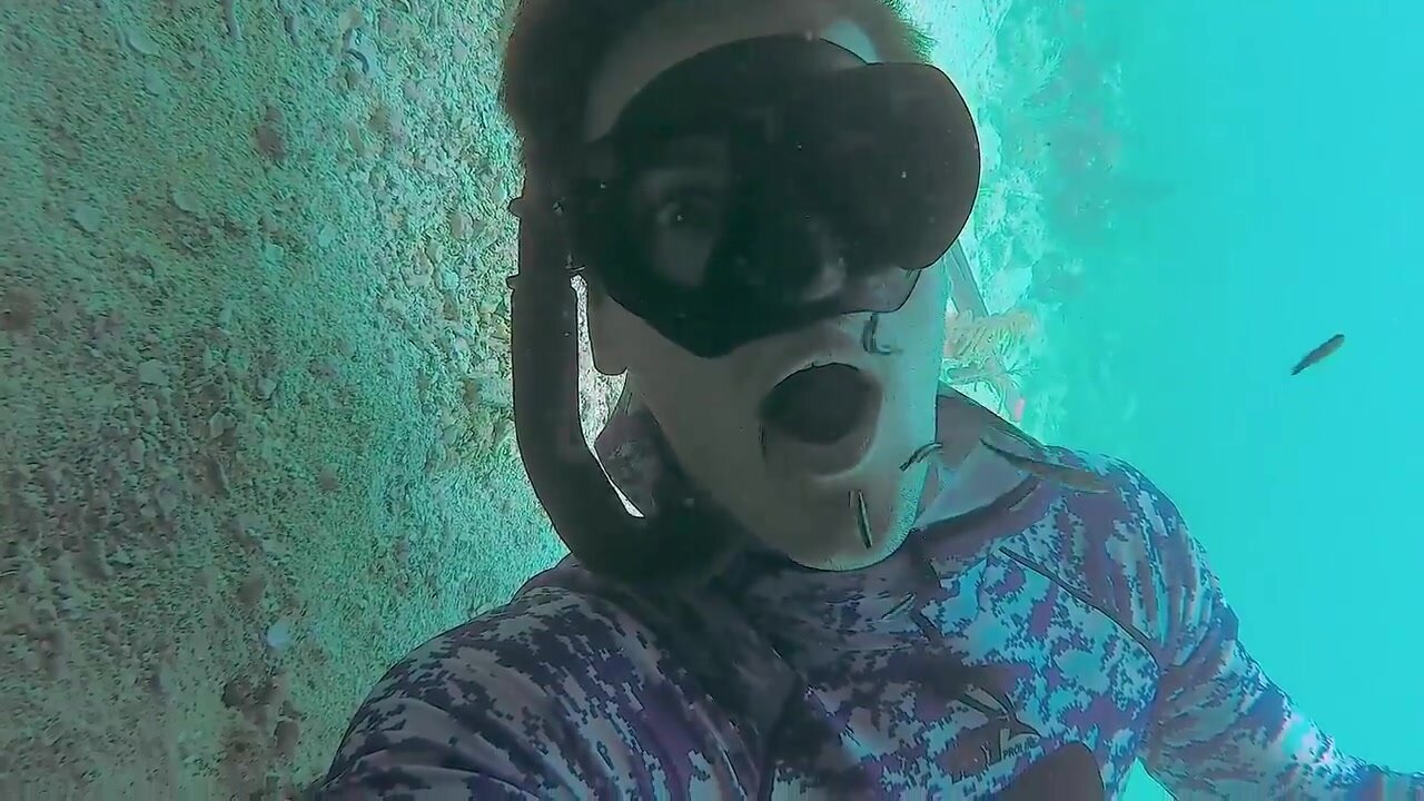 Breatholding mouth open underwater in tight wetsuit