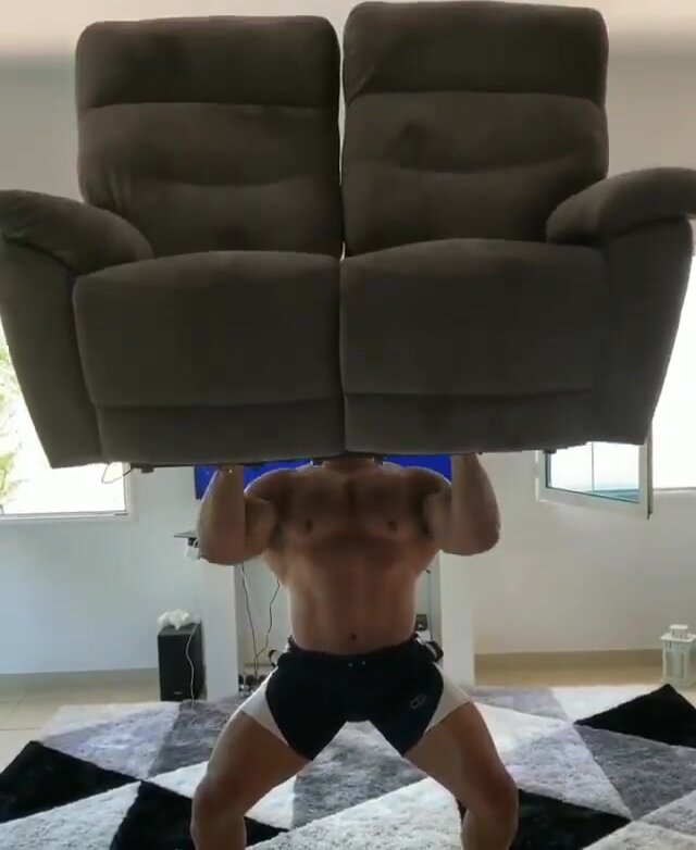 massive bodybuilder does workout with couch