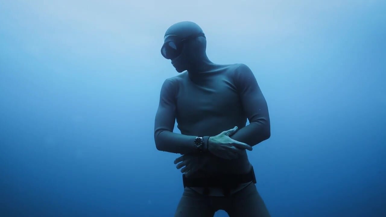 French freediver underwater in tight wetsuit
