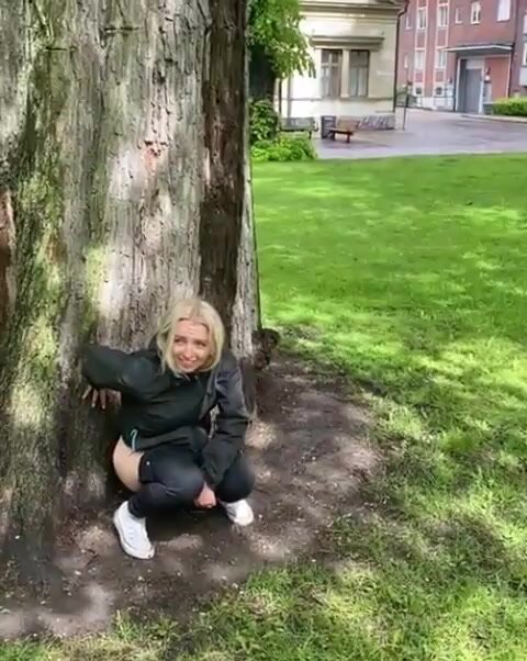 Woman peeing by tree 2