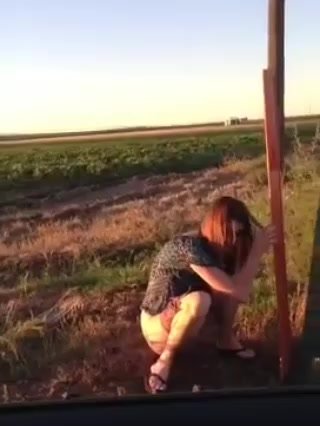 Woman peeing in the field