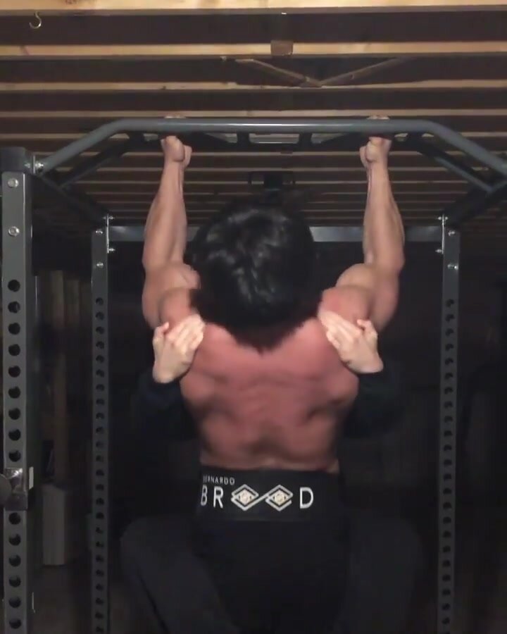 powerfull hunk does pull ups with GF showing muscles