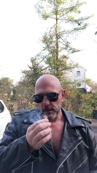 sexy daddy smokes in his leather biker jacket