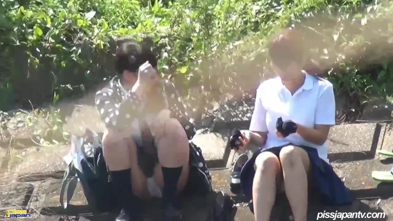 Japanese girls having fun peeing together outdoors