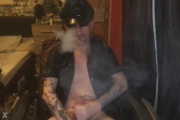 leather guy smokes his cigar while having a nice wank