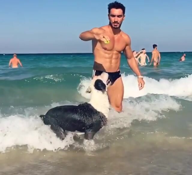 Hot guy in speedos playing with his dog
