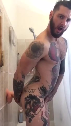 Tattooed beefy guy rides dildo and shoots