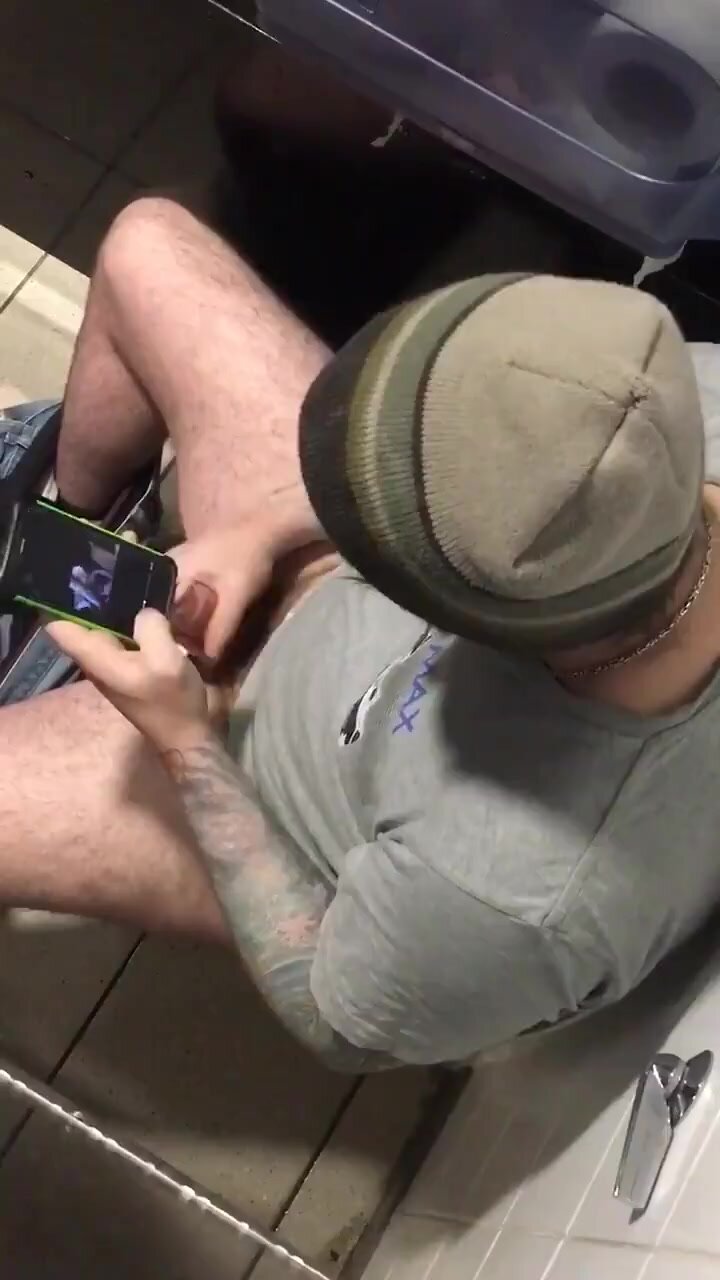 Tattooed guy jerking her off in toilet