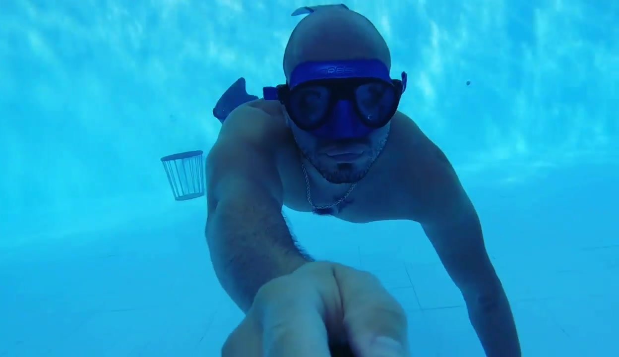 Bald guy swimming underwater with mask
