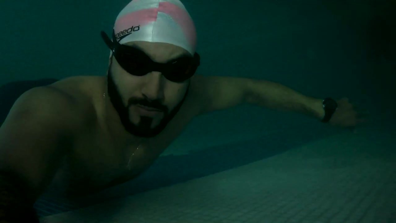 Arab fit swimmer underwater with goggles