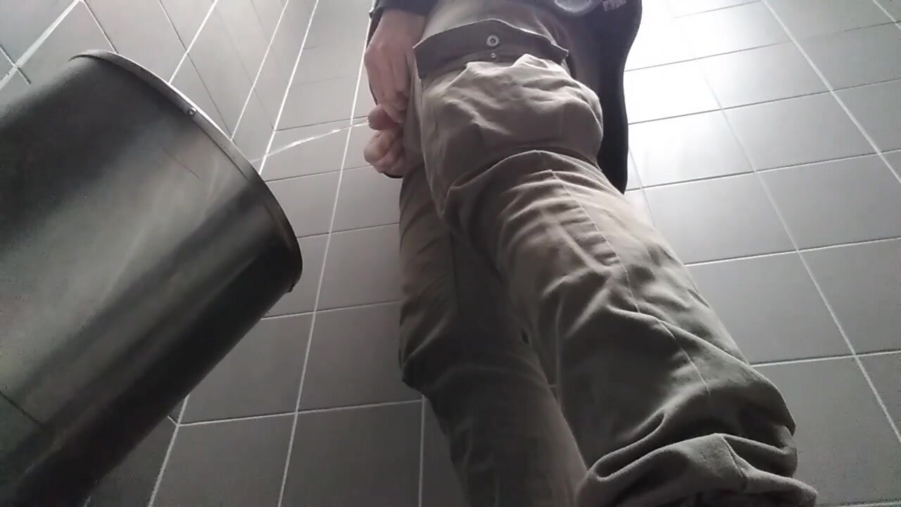 Young man with uncut dick peeing in a public urinal