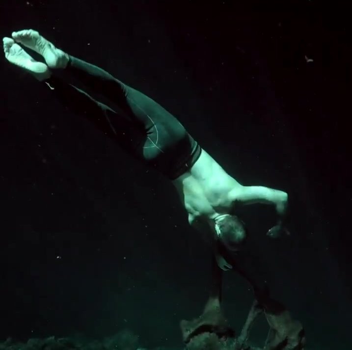 Underwater barefaced dancer in tights