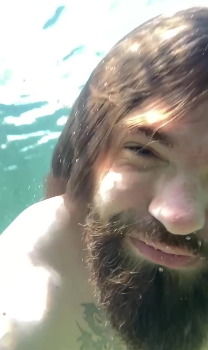 Long haired bearded guy barefaced underwater